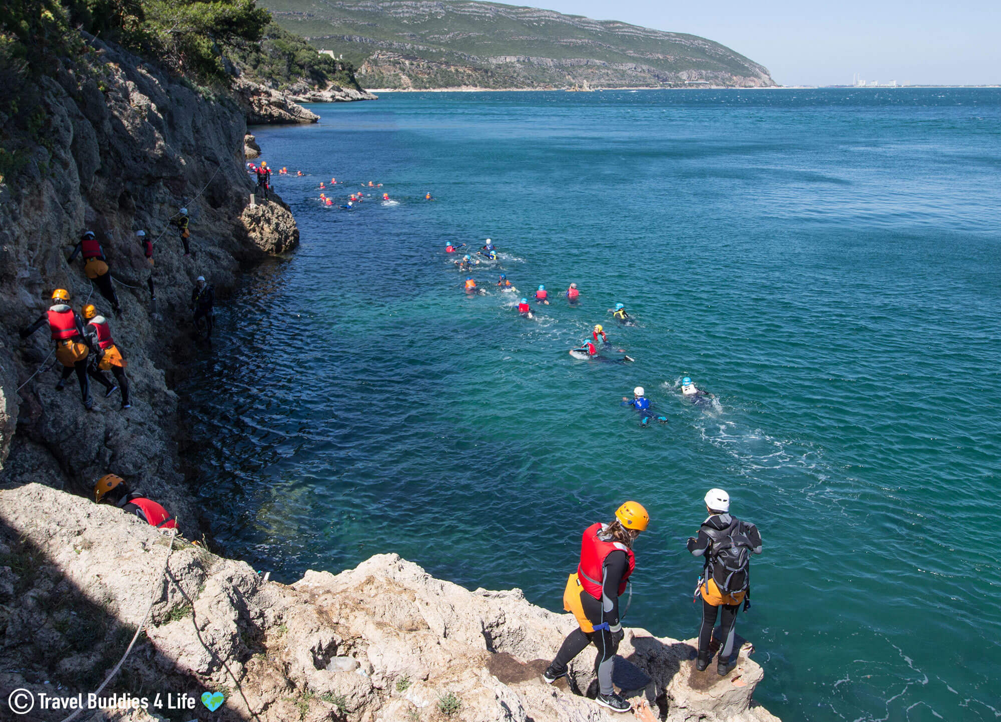 Coasteering Group in the Water Swimming to the Next Cliff Jumping Location in the Arrábida Nature Park